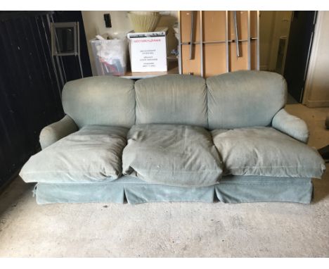 A modern upholstered three-seat sofa in the style of Howard of London, the sides with curved rails raised on turned and ringe