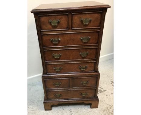 A modern mahogany cabinet as a miniature Georgian chest on chest, the feather-banded rising top with moulded edge over two sh