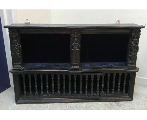 A 19th Century oak wall cupboard, the plain top with applied moulded edge over an open shelf decorated with carved figural st