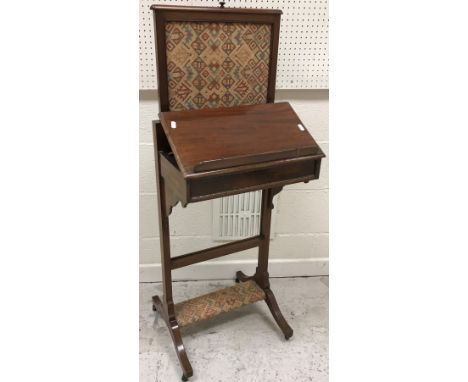 An Edwardian mahogany fireside reading stand with pop-up screen and ratchet bookstand on end pillar supports, united by an up