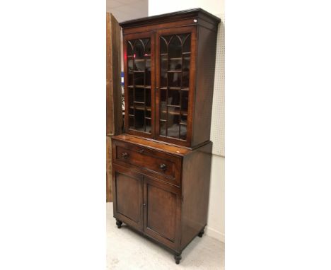 A late Regency mahogany secretaire bookcase of small proportions, the upper section with reeded cornice over two Gothic arch 