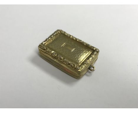 An early Victorian silver gilt vinaigrette with engine-turned and relief work scrolling foliate decoration, opening to reveal