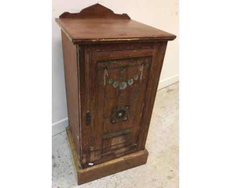 A late Victorian oak and carved and painted pot cupboard in the Arts &amp; Crafts manner, the single door decorated with flor