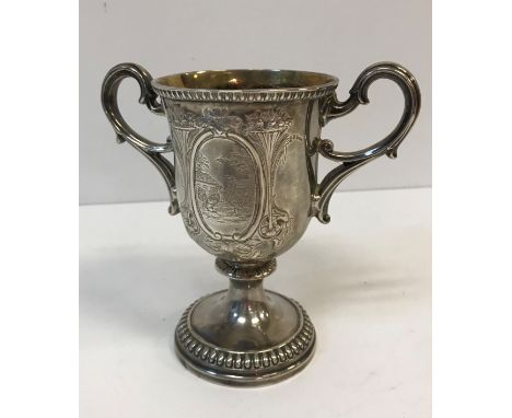 A Victorian silver trophy cup with embossed decoration and panel depicting a cockerel and hen in a farmyard setting, inscribe