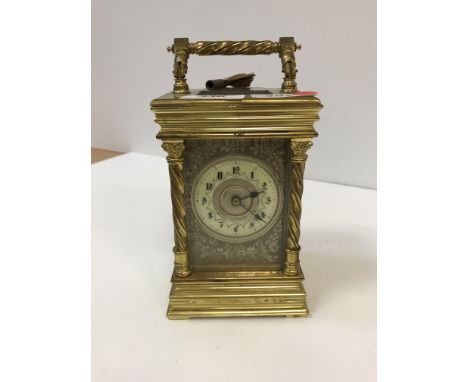 A late 19th century gilt brass cased French carriage clock, the folding rope twist handle above a visible escapement with sil