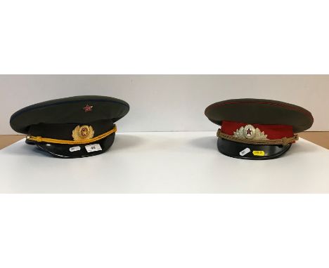 Two Russian military peaked caps, each with red enamel star hammer and sickle badges