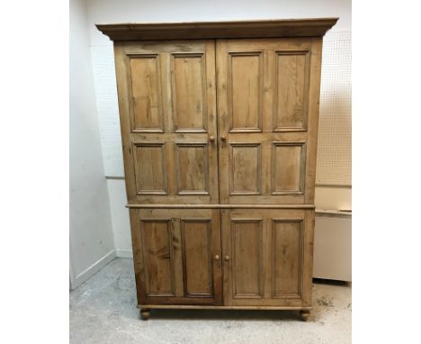 A Victorian waxed pine cupboard, the moulded cornice above a pair of four-panel doors enclosing three shelves over two twin-p