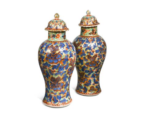 A pair of Chinese blue and white porcelain 'clobbered' vases, 18th century,  each baluster vase painted with dense scrolling 