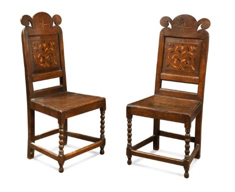 A pair of oak marquetry side chairs, circa 1700, with floral inlaid panelled backs above solid seats and bobbin turned front 