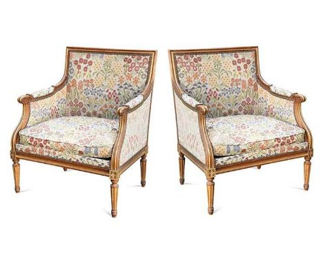 A pair of French beech and gilt painted bergère armchairs, early 20th century,  the carved and moulded frames on tapered and 
