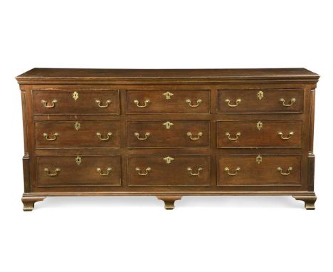 A George III oak and mahogany dresser base,  comprising nine drawers flanked by fluted pilasters on ogee bracket feet 91 x 19
