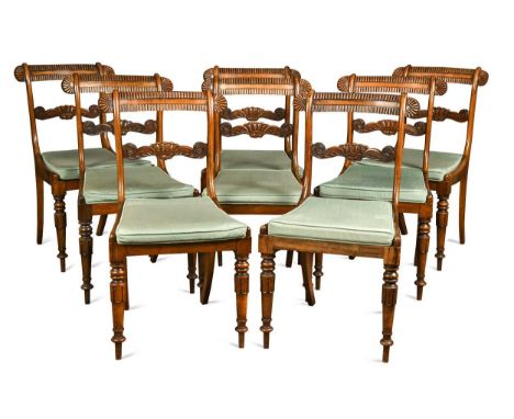 A set of eight Regency rosewood dining chairs, the carved bar backs over caned seats raised on turned and lapet carved front 