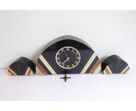 A French Art Deco marble and black-slate arched, shaped mantel clock, the chapter ring with Arabic numerals and the clock fla