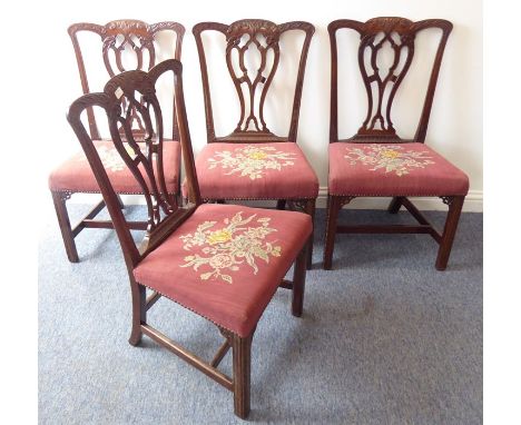 A set of four late 19th / early 20th century mahogany salon chairs in 18th century Chippendale style; the top rails carved wi