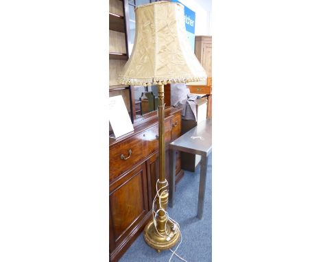 A gilt-wood lamp standard with extravagant tasselled shade; the fluted stem above a stiff plantain-leaf bulb and on circular 