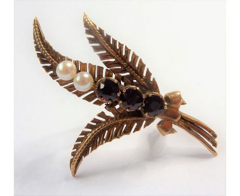 A 9-carat yellow-gold brooch modelled as three ferns centrally set with two seed pearls and three garnets
(The cost of&nbsp;U