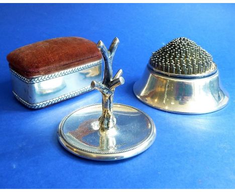 A small silver group to include an early 20th century silver-sided pincushion having hinged lid, one other circular example a