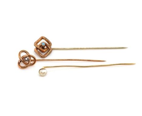 Two antique gold and gemstone stick pins set with a diamond, a pearl as well as a gilt metal piece. Two marked to pin. One wi