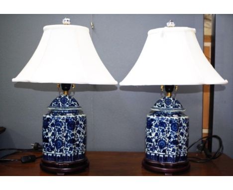 Pair Chinese blue &amp; white table lamps each ceramic base with blue and white decoration, on wood base, with fabric lamp sh