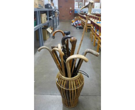 A collection of walking sticks, unbrella in a wicker stick stand **PLEASE NOTE THIS LOT IS NOT ELIGIBLE FOR IN-HOUSE POSTING 