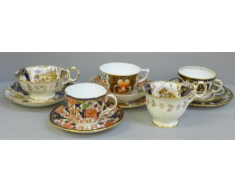 A collection of Derby and Royal Crown Derby Queen's Imari cabinet cups and saucers; two with tea plates and a cup and saucer 