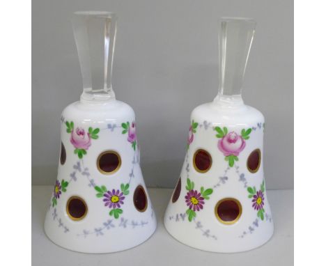 A pair of Bohemian glass bells, cased milk glass cut to ruby with hand painted flowers, clear glass handles, 13cm 