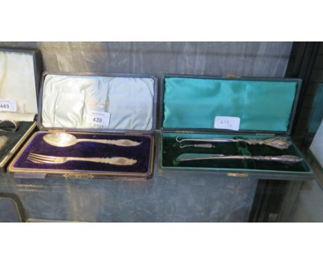 A child's cased silver spoon and fork together with a cased shoe horn and button hook