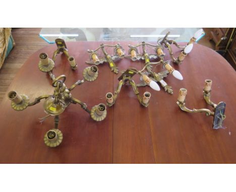 Three wing form brass twin wall lights, four scroll form twin wall lights and a similar five-light chandelier