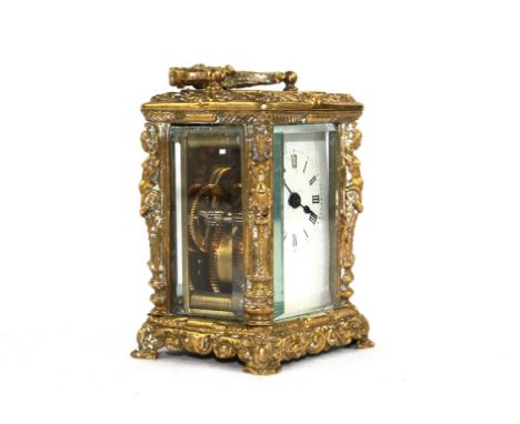 A miniature carriage clock in a decorative brass case with white enamel dial, 9.5cm high