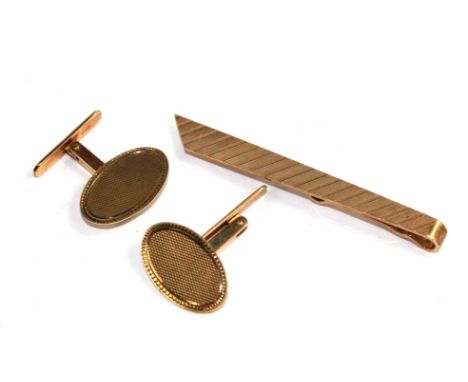 A gold tie pin and cufflinks