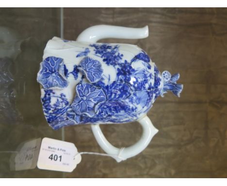 An Oriental blue and white teapot with applied lilly design, unmarked, handle repaired 15cm high