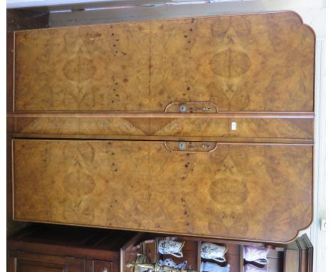 A two piece 1920s burr walnut bedroom suite, comprising wardrobe and dressing table, wardrobe 119cm wide a pair of brass sing