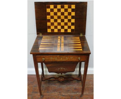 An Edwardian rosewood and marquetry ladies work and games table, the hinged top opening to reveal a chessboard and backgammon