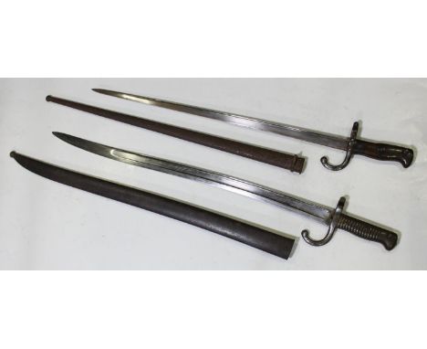 A French 1876 pattern bayonet with 20.5" blade, wooden grip, metal scabbard, together with a French 1874 Pattern bayonet with