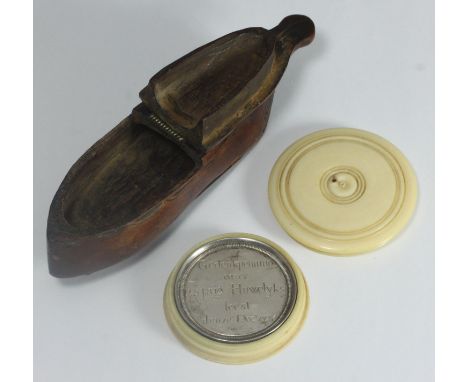 A treen snuff box in the shape of a ladies shoe, together with a Dutch silver token engraved in commemoration to a 25th anniv