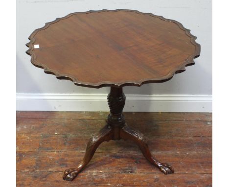 A 19th century stained mahogany tripod table, with piecrust top, baluster column and three down-swept supports to claw and ba
