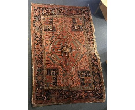 A Caucasian hand-knotted carpet, central frieze with blue and pink stylised geometric shapes to red ground and dark blue bord