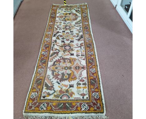 A wool runner with stylised earthy coloured flowers on a cream ground