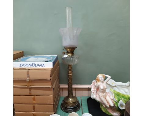 A Victorian brass oil lamp of tall proportions with moulded brass column, cut glass reservoir and etched glass shade, height 