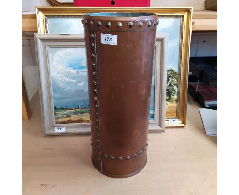 A riveted copper stick stand plus two framed oils, one of a harvest scene the other 'Cove Hythe' by John Constable Reeve