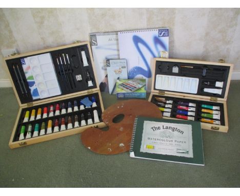 Artists accessories to include two boxes of watercolour paints, an easel and sketch books 