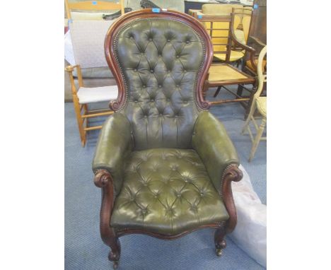 A Victorian spoon back salon armchair having green button and stud leather back upholstery 