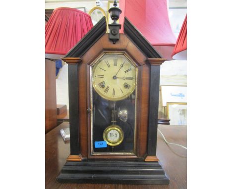 A late 19th century and ebonized cased mantle clock with twin winding holes, painted roman dial, movement striking on a bell,