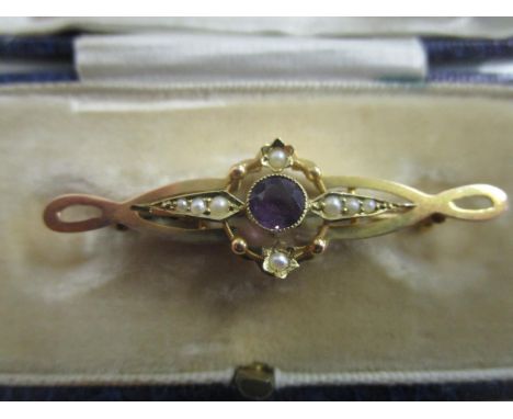 A Victorian 15ct yellow gold bar brooch set with a central amethyst stone and seed pearls, total weight 2.4g, in a F W Gibson