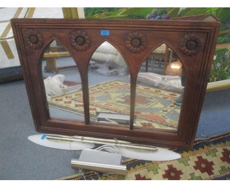 A carved wooden framed mirror and a light fitting 