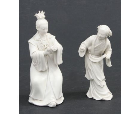 A Chinese blanc de chine figure depicting a wise man holding a scroll, 16cms high; together with another similar, 13.5cms hig