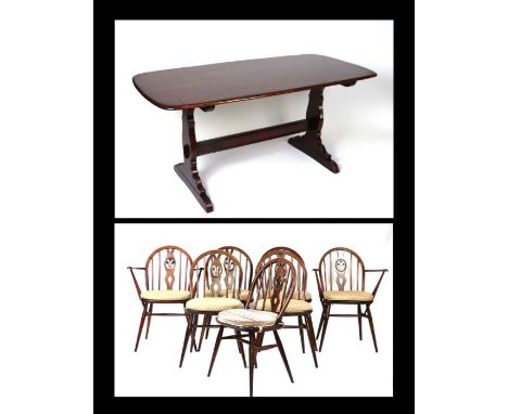 An Ercol mid century oak refectory style dining table, 142cms wide; together with six matching Ercol Windsor style hoop back 