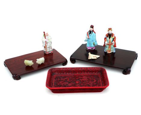 A Chinese hardwood stand, 36cms wide;' together with another similar, 32cms wide; two carved jade pigs, 5cms wide; three figu