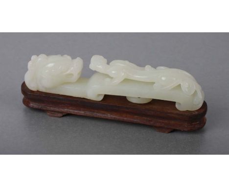 A Chinese jade / hardstone belt hook in the form of a chilong, on an associated hardwood stand, 12cms long.Condition ReportGo
