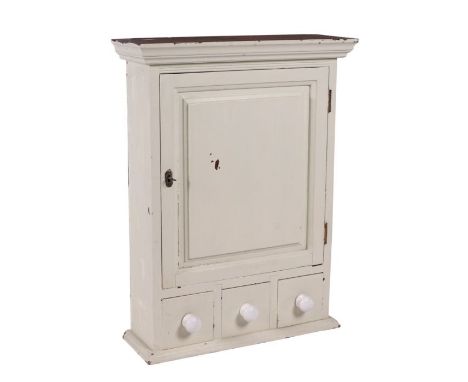 A painted pine wall cabinet with single panelled door enclosing a shelved interior, above three drawers, 53cms wide.